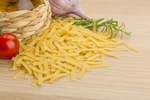 rå pasta på träbakgrund foto