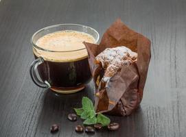 kaffe med muffin på trä- bakgrund foto