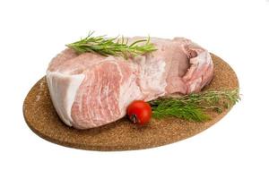 rå fläsk kött på trä- tallrik och vit bakgrund foto