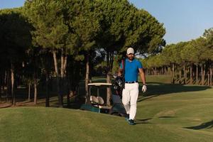 golfspelare gående och bärande golf väska foto