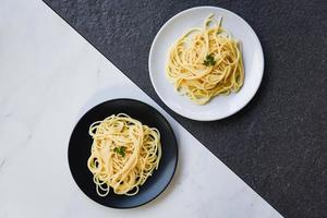 spaghetti italiensk pasta eras på vit tallrik och svart tallrik spaghetti mat och meny begrepp foto