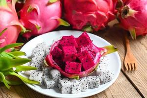 drake frukt skiva på vit tallrik med pitahaya bakgrund, färsk vit och rosa röd lila drake frukt tropisk i de asiatisk thailand friska frukt begrepp foto
