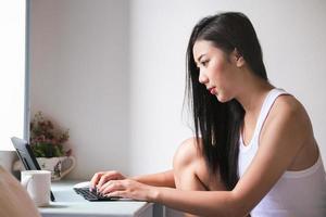 ny vanligt, en affärskvinna använder sig av dator till arbete för en företag via de internet på din skrivbord på Hem. foto