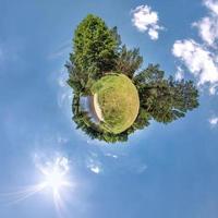 grön liten planet omvandling av sfärisk panorama 360 grader. sfärisk abstrakt antenn se i fält med klar himmel och grymt bra skön moln. krökning av Plats. foto