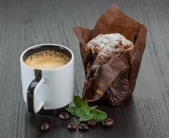 kaffe med muffin på trä- bakgrund foto