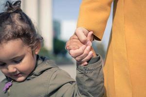 mor och dotter innehav händer. foto