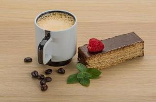 kaffe med kaka på trä- bakgrund foto