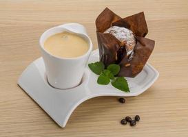 kaffe med muffin på trä- bakgrund foto