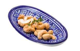 cashew i en skål på vit bakgrund foto