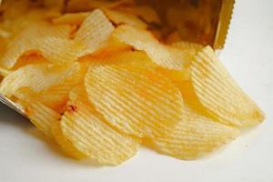 potatischips i öppen påse, läcker grillkrydda kryddig för crips, tunn skiva friterad snack snabbmat. foto