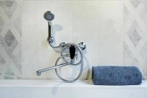 vattenkran handfat med kran i dyrt loft badrum. detalj av en hörnduschkabin med väggmonterad duschfäste foto