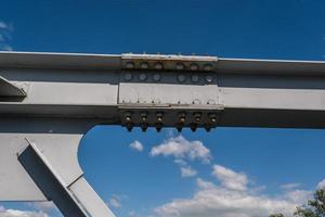 järn stål ram konstruktion av bro på blå himmel bakgrund. bro metall strukturer, ramar, bultar och nötter foto
