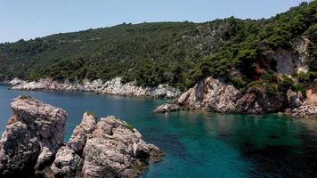 flygdrönarevyer över en klippig kustlinje, kristallklart vatten i Egeiska havet, turistiska stränder och massor av grönska på ön Skopelos, Grekland. en typisk utsikt över många liknande grekiska öar. foto