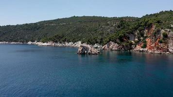 flygdrönarevyer över en klippig kustlinje, kristallklart vatten i Egeiska havet, turistiska stränder och massor av grönska på ön Skopelos, Grekland. en typisk utsikt över många liknande grekiska öar. foto