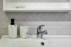 keramisk vattenkran diskbänk med kran med tvål och schampo dispensrar i dyra loft badrum eller kök foto