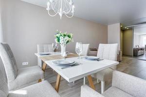eras tabell med en bukett av ro i interiör av modern lyx gäst rum i studio lägenheter i minimalistisk stil foto