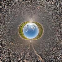 blå himmel boll i mitten av virvlande asfalt väg eller fält. inversion av liten planettransformation av sfäriskt panorama 360 grader. sfärisk abstrakt syn. utrymmets krökning. foto