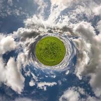 mycket liten planet omvandling av sfärisk panorama 360 grader. sfärisk abstrakt antenn se i fält med klar himmel och grymt bra skön moln. krökning av Plats. foto