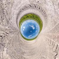 inversion av blå liten planet transformation av sfäriskt panorama 360 grader. sfärisk abstrakt flygfoto på vägen med fantastiska vackra moln. utrymmets krökning. foto