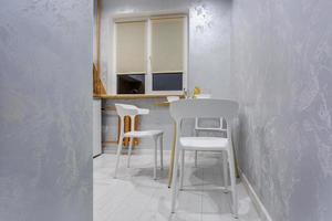 bekväm stolar och tabell med blommor i interiör de modern levande rum eller kök foto