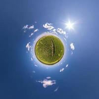 liten planet omvandling av sfärisk panorama 360 grader. sfärisk abstrakt antenn se i fält med klar himmel och grymt bra skön moln. krökning av Plats. foto