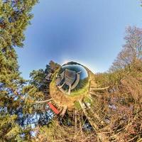 grön mycket liten planet omvandling av sfärisk panorama 360 grader. sfärisk abstrakt antenn se på skog. krökning av Plats. foto