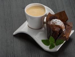 kaffe med muffin på trä- bakgrund foto