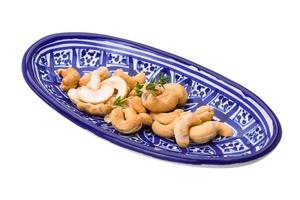 cashew i en skål på vit bakgrund foto