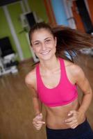 kvinna utövar på löpband i Gym foto