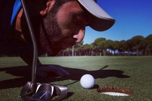 golf spelare blåser boll i hål foto