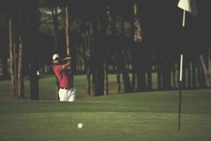 golfspelare slå en sand bunkra skott foto