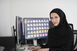 ung muslim flicka arbetssätt på de dator från Hem foto