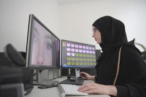 ung muslim flicka arbetssätt på de dator från Hem foto