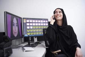 muslim kvinna grafisk designer talande på de telefon foto