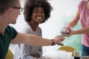 multietnisk grupp av ung människor ha en lunch ha sönder foto