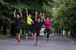 löpare team Hoppar i de luft under morgon- Träning foto