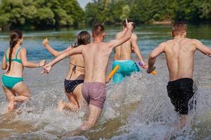 grupp av Lycklig vänner har roligt på flod foto