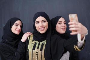 muslim kvinnor tar selfie bild i främre av svart svarta tavlan foto