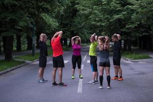 löpare team uppvärmningen upp och stretching innan morgon- Träning foto