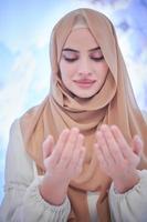 skön muslim kvinna framställning traditionell bön till Gud foto