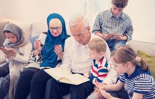 modern muslim farföräldrar med barnbarn läsning quran foto