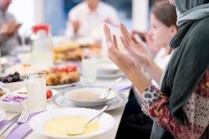 modern multietnisk muslim familj bön- innan har iftar middag foto