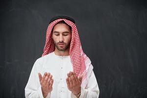 arab man i traditionell kläder bön- till Gud eller framställning dua foto