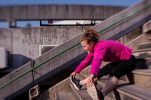 kvinna stretching innan morgon- joggning foto