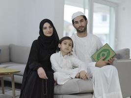 ung muslim familj läsning quran under ramadan foto