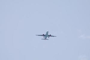kommersiell flygplan flygande under blå himmel och anländer på de flygplats foto