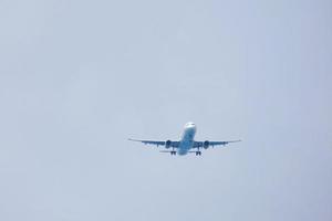 kommersiell flygplan flygande under blå himmel och anländer på de flygplats foto