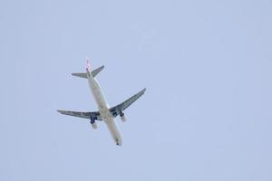 kommersiell flygplan flygande under blå himmel och anländer på de flygplats foto