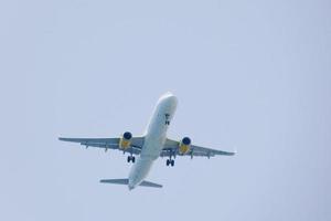 kommersiell flygplan flygande under blå himmel och anländer på de flygplats foto