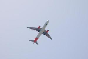 kommersiell flygplan flygande under blå himmel och anländer på de flygplats foto